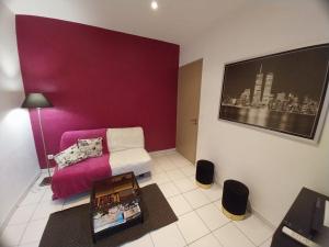 a living room with a couch and a purple wall at Lou pescadou in Saint-Raphaël