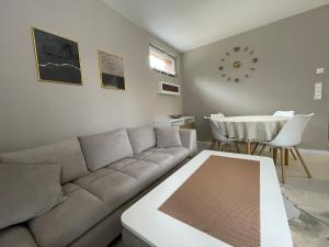 a living room with a couch and a table and a clock at Apartmani Berg in Pale +64 photos