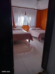um quarto com 2 camas e uma janela em Residencia MJN em Chignahuapan