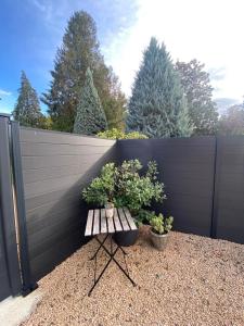 un banc avec deux plantes en pot à côté d'une clôture dans l'établissement A LA BELLE ETOILE, à Montbrison