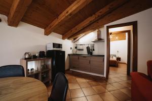 uma cozinha com um frigorífico e uma mesa num quarto em Maison Petit Rouge Aosta em Aosta