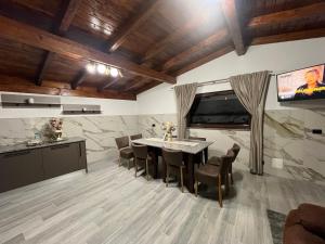 a dining room with a table and chairs and a tv at Villa Mery in Moisei