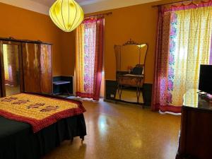 a bedroom with a bed and a mirror and a chandelier at Casa Mariuccia in Anzio