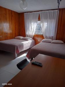 um quarto com 2 camas e um controlo remoto sobre uma secretária em Residencia MJN em Chignahuapan