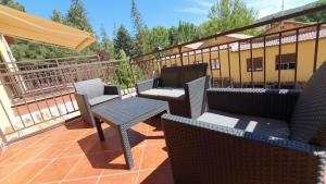 un patio con sillas y mesas en un balcón en Casa Rural Los Níscalos, en Tragacete