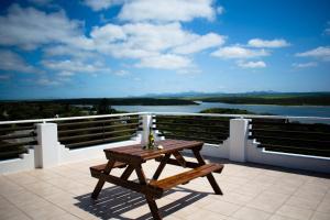 a picnic table on a balcony with a view of a river at Aguia-Vista Couples Haven, Views, Pool, Beach Walk in Jeffreys Bay