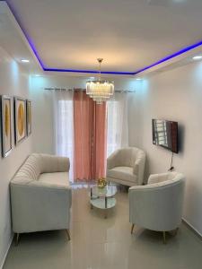 a living room with two white couches and a tv at Apartamento Amueblado en Bonao in Bonao