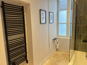 een badkamer met een douche en een glazen deur bij Bella Vita in Villers-Cotterêts