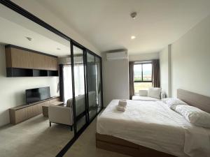 een slaapkamer met een groot bed en een tv bij Downtown In Huahin la casita in Hua Hin