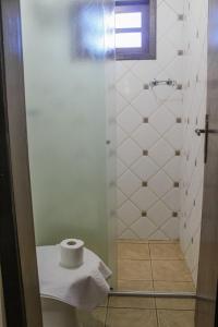 a bathroom with a roll of toilet paper in a shower at Serramar Apart Hotel in Capão da Canoa