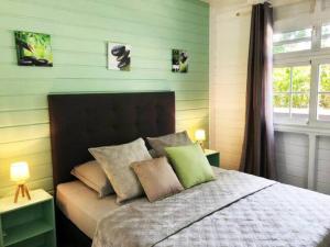 um quarto com uma cama com paredes verdes em Villa Kylise em Baie-Mahault