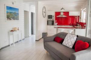 uma sala de estar com um sofá e uma cozinha vermelha em Villa Kylise em Baie-Mahault