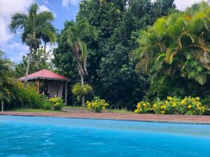 um resort com piscina e palmeiras em Villa Kylise em Baie-Mahault