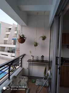 a balcony with a table and potted plants on the wall at Apartasol San Jerónimo in San Jerónimo