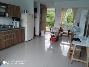 uma cozinha com um frigorífico, uma mesa e cadeiras em Apartasol San Jerónimo em San Jerónimo