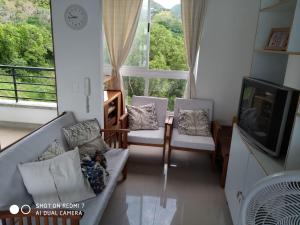 a living room with a couch and chairs and a tv at Apartasol San Jerónimo in San Jerónimo
