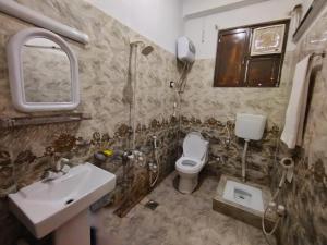 uma casa de banho com um lavatório, um WC e um espelho. em Swat Hilton Hotel by Khan Familia em Suat