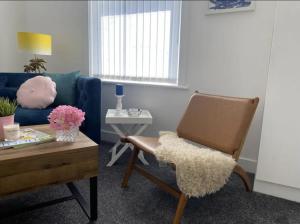 - un salon avec un canapé bleu et une chaise dans l'établissement Santiago Suite 4 - A Beautiful Duplex Flat, à Southport