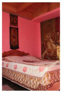 a pink bedroom with a bed with a painting on the wall at MOEDANZE in Tʼelavi