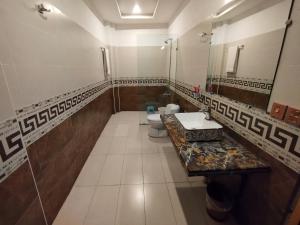 a bathroom with two toilets and a sink and a mirror at Swat Hilton Hotel by Khan Familia in Swat