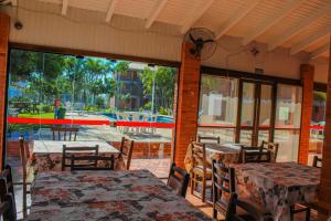 a restaurant with tables and chairs and a large window at Serramar Apart Hotel in Capão da Canoa