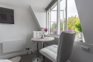 a white room with a table and a chair and a window at Parade Paradise- Secret Views, LEDs, 4K TVs, 5G WIFI and more! in Bath