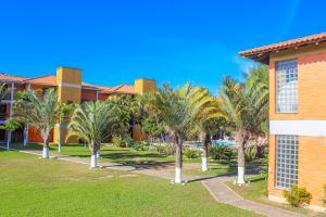 a row of palm trees in front of a building at Serramar Apart Hotel in Capão da Canoa