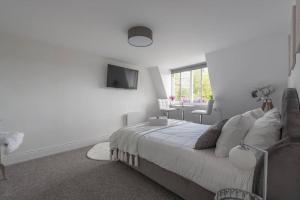a white bedroom with a bed and a television at Parade Paradise- Secret Views, LEDs, 4K TVs, 5G WIFI and more! in Bath