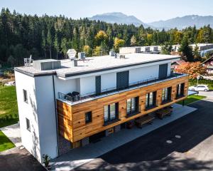 - une vue aérienne sur un bâtiment blanc avec une terrasse dans l'établissement KULA Comfort Rooms, à Villach