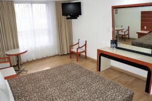 ein Hotelzimmer mit einem Bett und einem Spiegel in der Unterkunft Hotel Princesa in Mexiko-Stadt