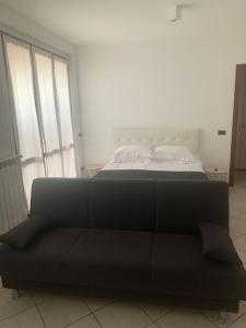 Sofá negro en una habitación con cama en Jasmine garden apartment, en Capriate San Gervasio
