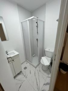 La salle de bains blanche est pourvue d'une douche et de toilettes. dans l'établissement Large double room 2 with en-suite bathroom and Belcony, à Oeiras