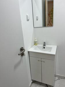 a white bathroom with a sink and a mirror at Large double room 2 with en-suite bathroom and Belcony in Oeiras