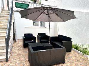 un parasol installé sur une terrasse avec deux chaises et un parasol dans l'établissement Large double room 2 with en-suite bathroom and Belcony, à Oeiras
