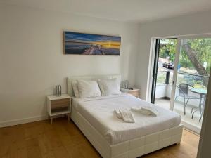 una camera bianca con letto e balcone di Large double room 2 with en-suite bathroom and Belcony a Oeiras