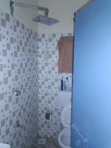 łazienka z toaletą i ścianą wyłożoną kafelkami w obiekcie Jamagere Homes near Palm Oasis w mieście Garissa
