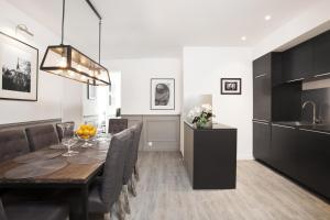 a dining room with a table and a kitchen at LivinParis - Luxury 3 Bedrooms Grands-Boulevards I in Paris