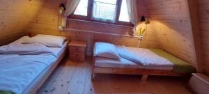 ein Zimmer mit zwei Betten in einer Blockhütte in der Unterkunft Domki LIDO Wicie in Vitte + 27 Fotos
