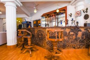 a bar with two stools in front of a counter at CherryStay Holiday Resort -Candolim Beach in Candolim