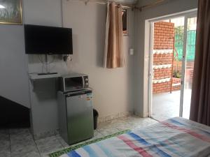 a room with a television and a small refrigerator at Silent Night Guest House Sunnyside Pretoria in Pretoria