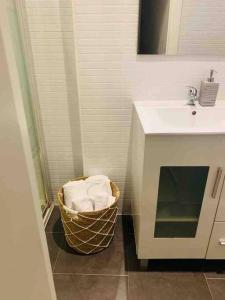 bagno con lavandino e cesto di asciugamani di Bien comunicado, acogedor y confortable a Coslada