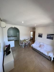 ein Wohnzimmer mit einem Bett und einem Tisch in der Unterkunft Apartamentos Maruja in Los Baños