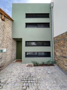 a building with three windows and a brick driveway at Casa do Cabo in Mós