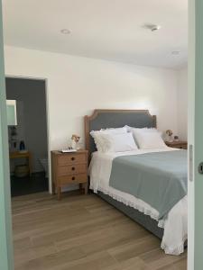 a bedroom with a large bed and a night stand at Casa do Cabo in Mós
