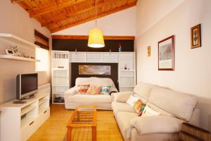 ein Wohnzimmer mit einem weißen Sofa und einem TV in der Unterkunft Jaen Catedral histórico in Jaén