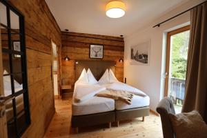 een slaapkamer met een bed met een houten muur bij Pension & Appartements Ronacherhof in Bad Kleinkirchheim