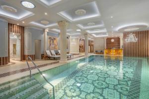 a swimming pool in a hotel with a lobby at Galicia Nueva, castle hotel in Lučenec