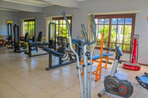 a gym with several treadmills and exercise bikes at Serramar Apart Hotel in Capão da Canoa