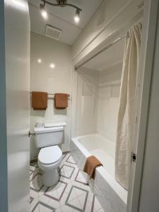 ein Badezimmer mit einem WC, einer Badewanne und einem Waschbecken in der Unterkunft Rest Easy Motel in Three Hills