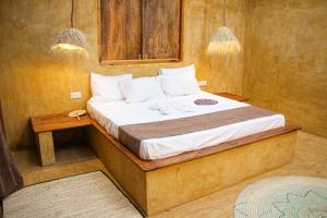 a bedroom with a bed with a wooden frame at Zanzigo in Nungwi